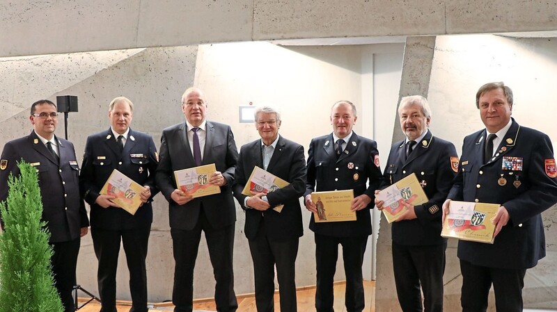 Die Chronik zum 150-jährigen Bestehen der Feuerwehrinspektion wird vorgestellt. Die Ehrengäste erhalten die ersten Exemplare.