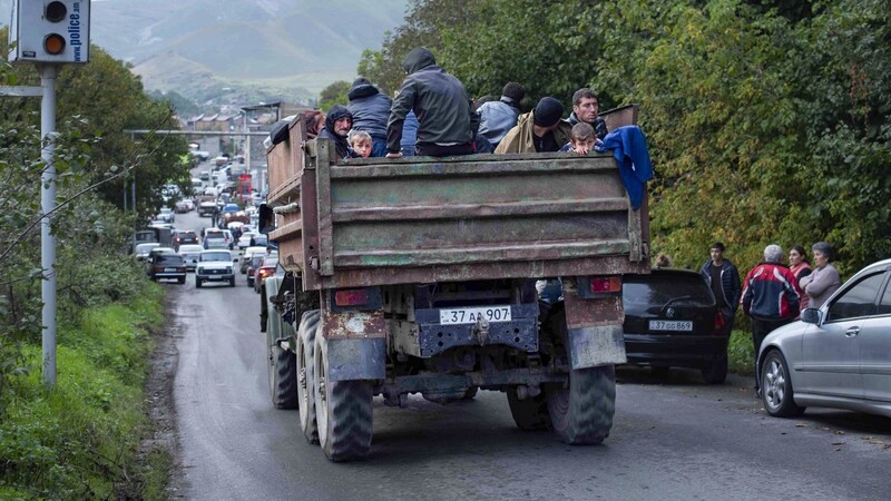 Ethnische Armenier aus Bergkarabach sitzen in einem Lastwagen auf dem Weg nach Goris in der Region Syunik. Nach der Eroberung des Gebietes Berg-Karabach durch Aserbaidschan wächst die Zahl der nach Armenien flüchtenden Menschen.