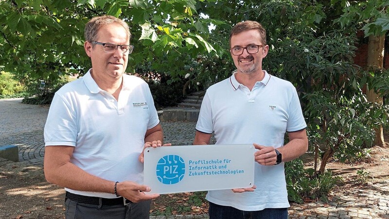 Schulleiter Alfred Reithmeier (l.) und Konrektor Franz Dippl mit dem Schild zur Auszeichnung. "Profilschule für Informatik und Zukunftstechnologien" ist darauf zu lesen.