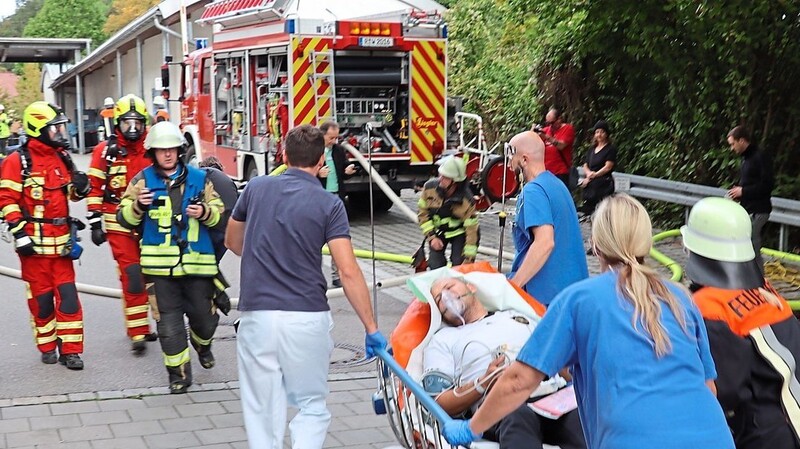 Wohl aus der Aufregung um den Zimmerbrand erlitt eine Person einen Herzinfarkt, zügig wird er zu den Rettungswagen gebracht.