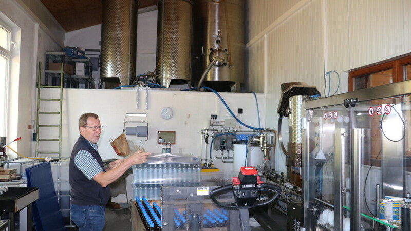 Bayola-Geschäftsführer Rupert Schmid steht vor dem großen Tank (oben rechts). Von dort läuft das filtrierte Öl in die Abfüllanlage (unten), anschließend werden die Flaschen händisch in die Etikettiermaschine gestellt.