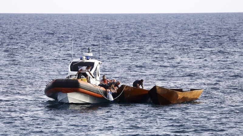 Mitarbeiter der italienischen Küstenwache bereiten sich darauf vor, Boote mit Migranten in der Nähe des Hafens der Insel Lampedusa abzuschleppen. Die Ankunft Tausender Bootsmigranten in kurzer Zeit hat die Insel Lampedusa vor wenigen Wochen an ihre Grenzen gebracht.