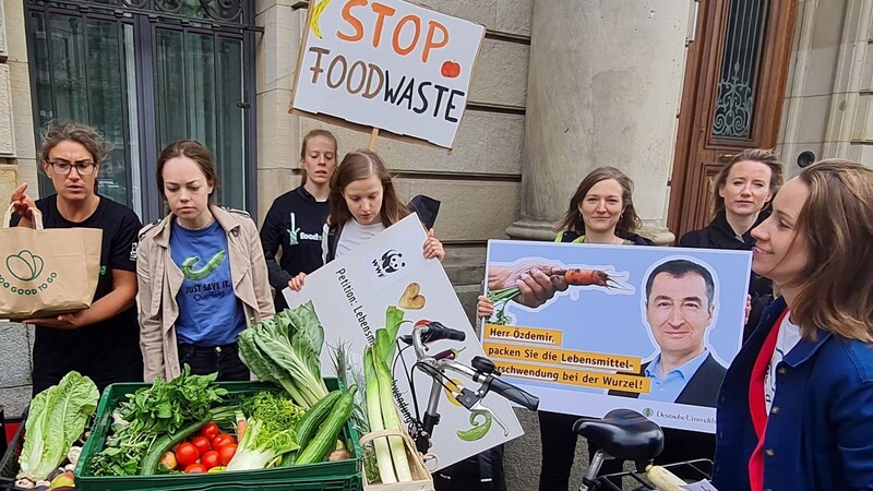 Umweltschützer stehen mit geretteten Lebensmitteln vor dem Ministerium. Im Jahr landen pro Verbraucher 75 Kilogramm auf dem Müll.