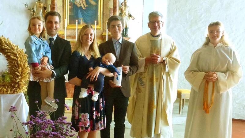 Täufling Jonas Gmach auf dem Arm seiner Mutter mit Papa Michael, Schwester Hannah, seinem Paten Johannes Achatz, Pfarrer Johann Wutz und Ministrantin Romy Haselsteiner.