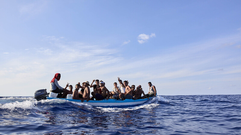 Eine Gruppe von Migranten Tunesien fährt in einem kleinen Fischerboot durch das Mittelmeer.