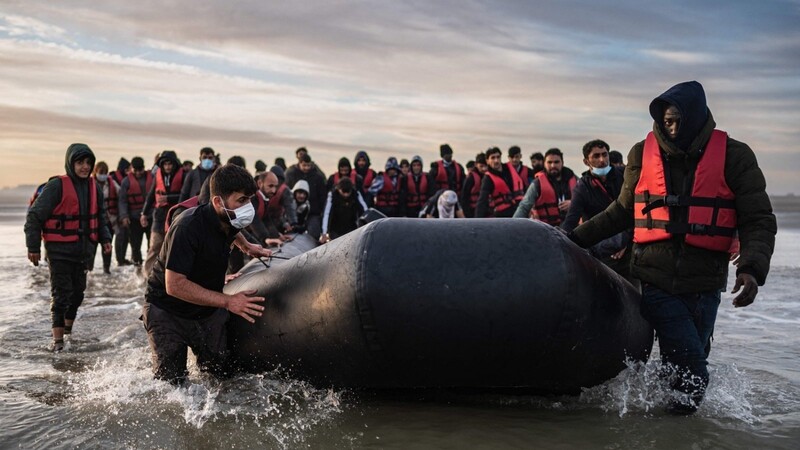 Migranten ziehen ein Schlauchboot aus dem Wasser am Strand von Gravelines. Mit einem Gummiboot von Frankreich über den Ärmelkanal nach Großbritannien zu fahren, ist riskant.