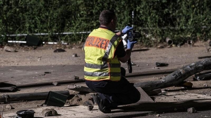 Ein Polizeibeamter fotografiert nach dem schweren Verkehrsunfall in Berlin-Mitte Spuren.