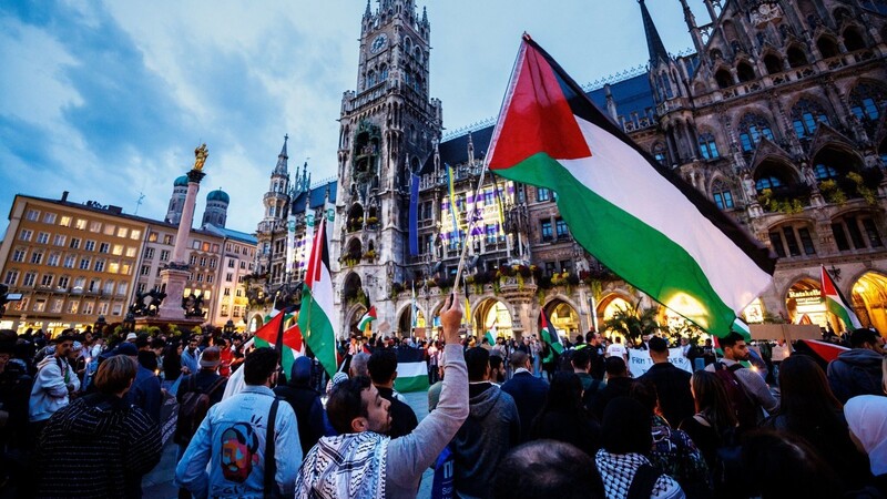 Ein Mann schwenkt während einer Kundgebung für Palästina auf dem Münchner Marienplatz eine palästinische Flagge.