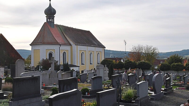 Die Tauben auf dem First der Sankt Salvatorkirche schauen vor Allerheiligen dem geschäftigen Treiben auf dem Friedhof zu.