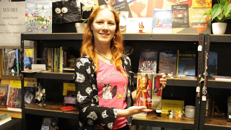 Christina Schwarzfischer in ihrem Laden mit einem ihrer Bücher: "Ich bin optimistisch, dass die Buchmesse heuer wieder ein Erfolg wird."