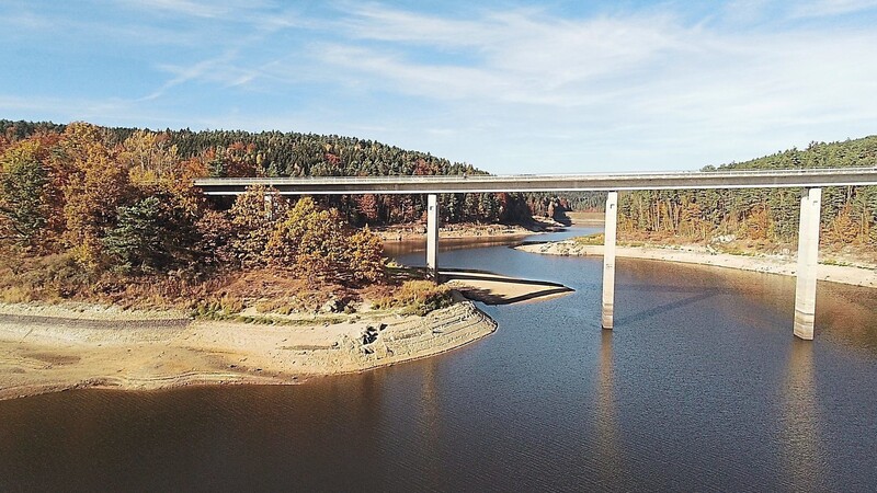 Über den Stausee führte die einmal längste Staatsstraßenbrücke Bayerns. Der abgesenkte Wasserspiegel legt das steile Ufer frei.