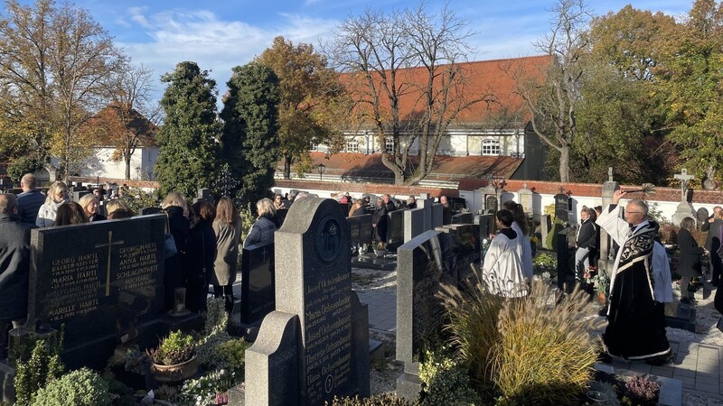 Pfarrer Dr. Werner Konrad geht mit Weihrauch und Weihwasser von Grab zu Grab.
