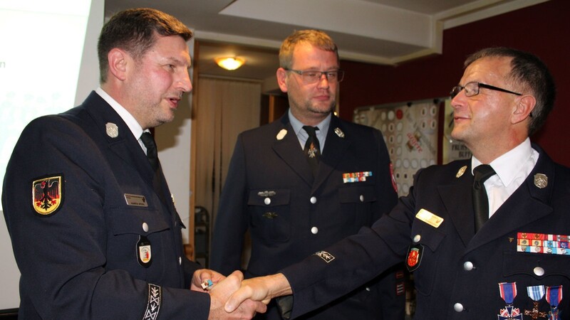Kommandant Johann Schweiger (Mitte) ist dabei als Kreisjugendwart Martin Sterl (li.) an Rudi Edenhofer für seine Verdienste in der frühkindlichen Brandschutzerziehung die Ehrennadel in Silber von der Kreisjugendfeuerwehr überreicht.