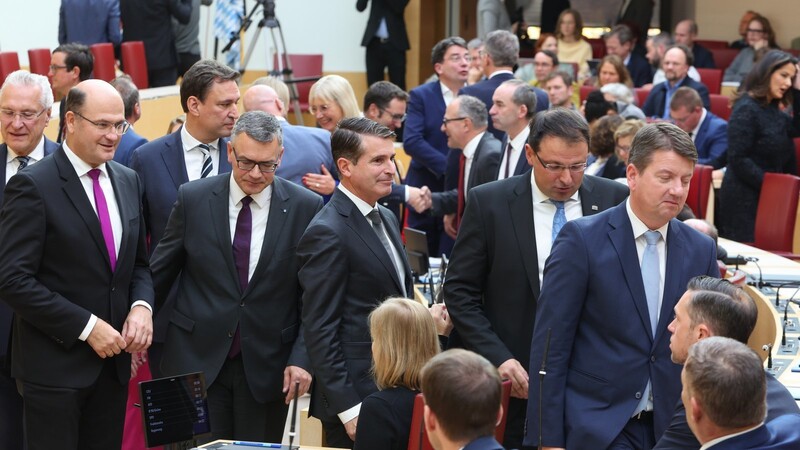 Mitglieder des neuen bayerischen Kabinetts stehen stehen nach der Vereidigung im Plenarsaal.