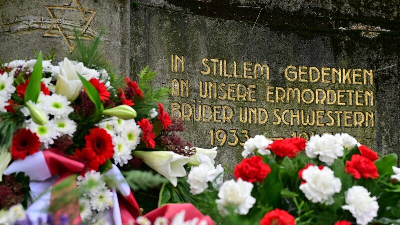 Blumen liegen vor einem Gedenkstein für bei den Novemberpogromen 1938 ermordete Juden während einer Gedenkveranstaltung auf einem jüdischen Friedhof.
