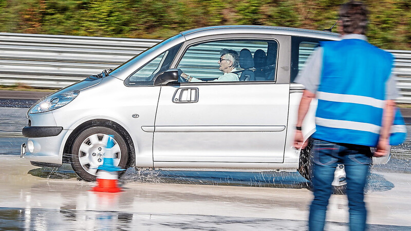 Eine Seniorin fährt mit ihrem Auto über eine Teststrecke.