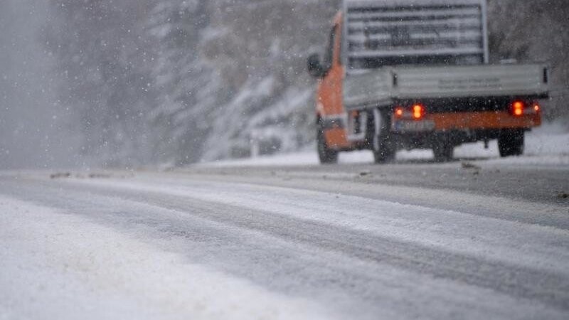 Ein Auto fährt bei dichtem Schneefall über eine Straße. Foto: Monika Skolimowska