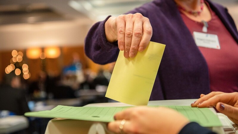 Ein Stimmzettel wird in einem Wahllokal eingeworfen.