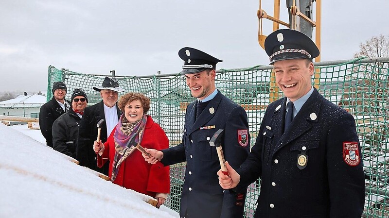 Symbolisch hämmern Vorsitzender Alexander Laube, Kommandant Patrick Hofweber und Bürgermeisterin Alexandra Riedl (von rechts) die letzten drei Nägel in die Dachkonstruktion.