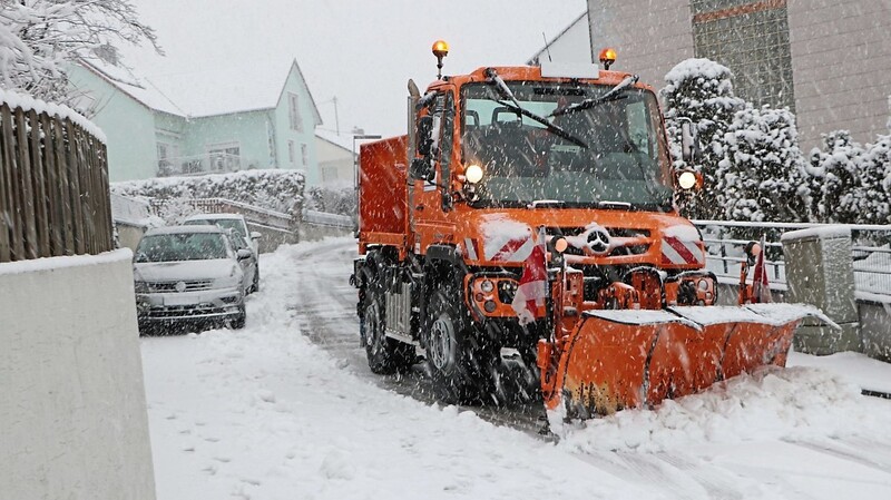Der Unimog im Einsatz bei heftigem Schneetreiben. Zugeparkte Straßen erschweren bisweilen die Arbeit des Räumdienstes,wenn es eng hergeht.