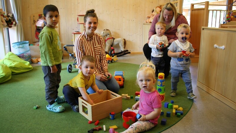 SPS-Praktikantin Franziska Augustin inmitten der Krippenkinder (und einer Mama, rechts), die mit Bauklötzen spielen.