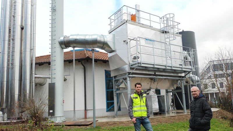 Projektingenieur Stefan Manger und Stadtwerke-Geschäftsführer Günter Winter vor der Abgasreinigungsanlage des neuen Pelletkessels.