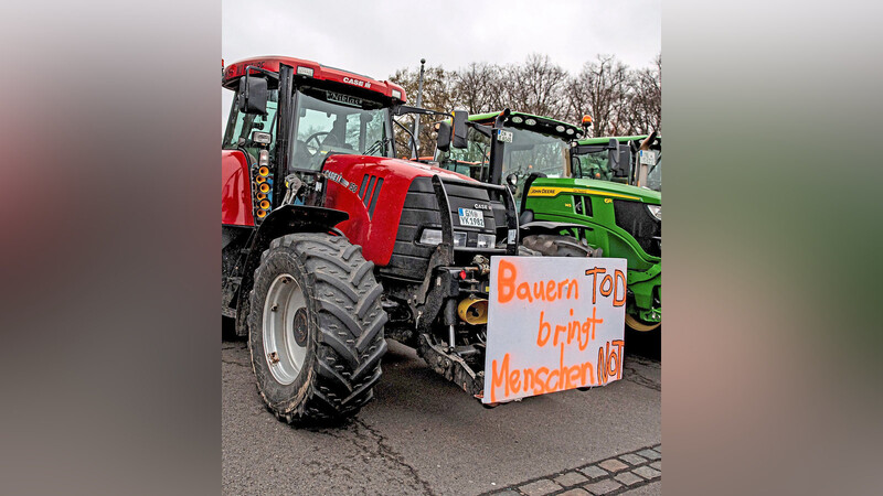 Landwirte protestieren mit Schildern und Traktoren in Berlin.