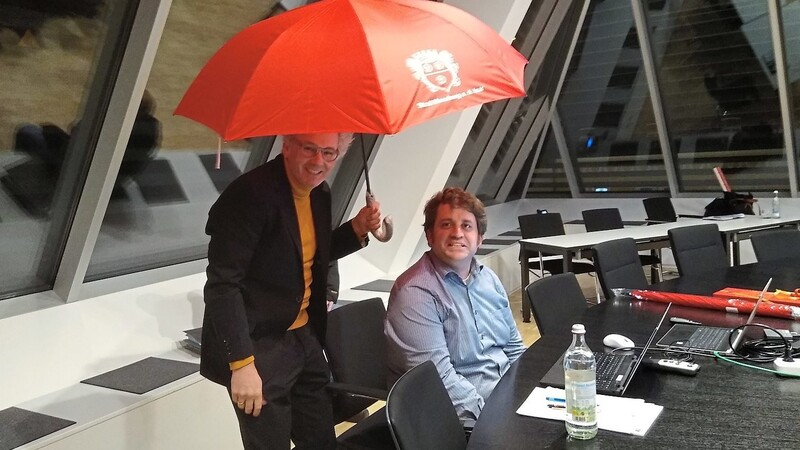 Kulturreferent Rudi Heinz spannt den Rettungsschirm für Kämmerer Martin Krumbucher auf. Die roten Schirme mit dem Dreirosen-Logo waren das Weihnachtsgeschenk für die Stadträte.