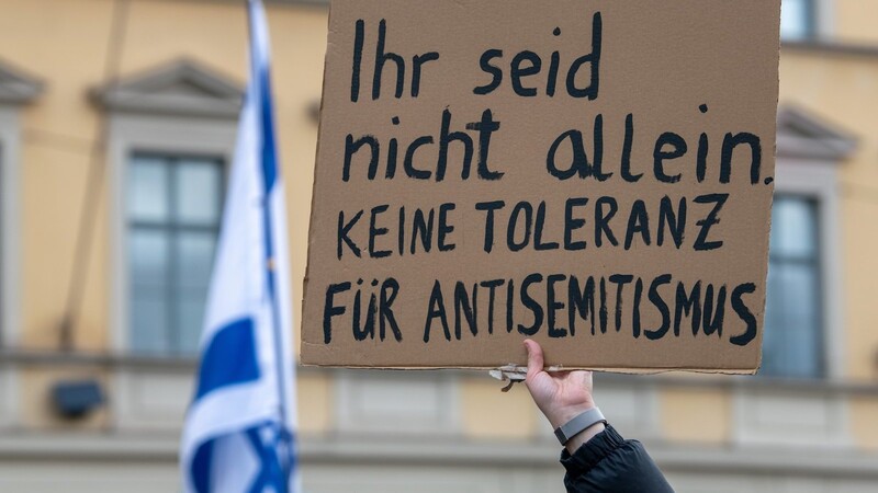 Bei einer Kundgebung für Israel in München hält eine Teilnehmerin ein Schild mit der Aufschrift "Ihr seid nicht allein. Keine Toleranz für Antisemitismus".