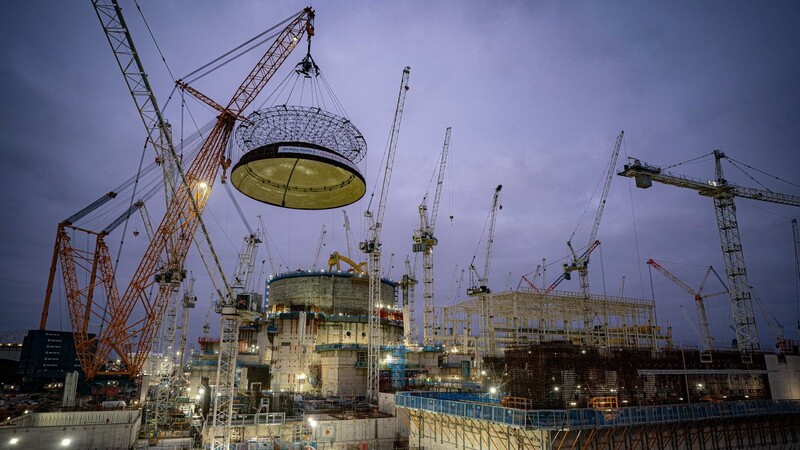 Ingenieurteams heben Mitte Dezember 2023 eine 245 Tonnen schwere Stahlkuppel auf das erste Reaktorgebäude von Hinkley Point C.
