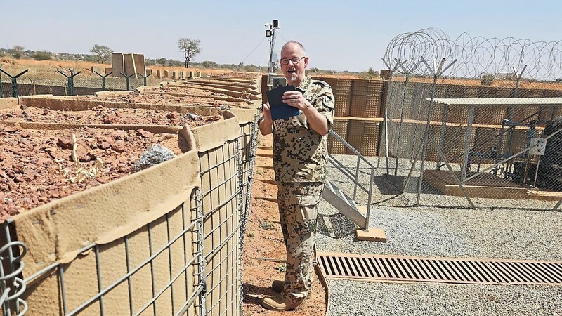 Pater Patrick wagt einen Blick über den Zaun des Stützpunkts beim Auslandseinsatz der Bundeswehr in Mali.