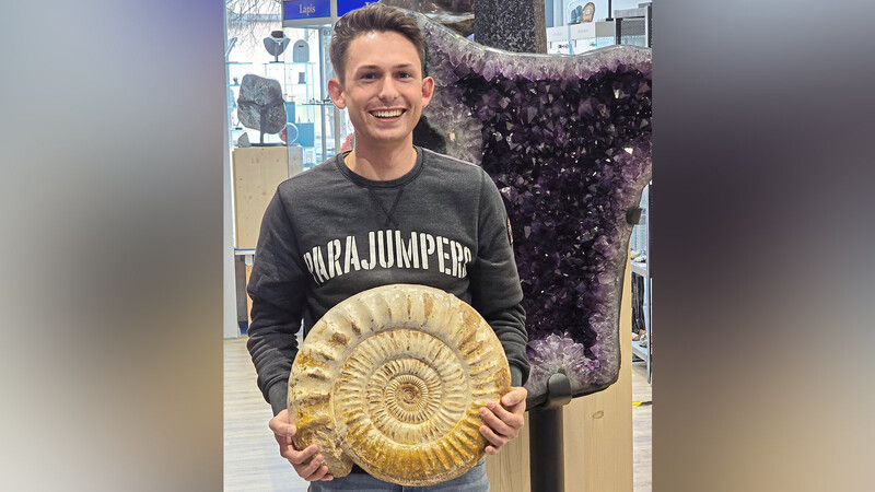 Seit seiner Kindheit sammelt Jonathan Lehner Mineralien und Fossilien. Im August zog er mit seinem Laden von der Ottogasse an den Theresienplatz. In der Hand hält er einen Ammonit.