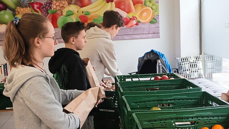 Michaela Hofbauer (v.l.), Tobias Jonza und Moritz Gebauer packen an einem Donnerstag Lebensmittel ab.