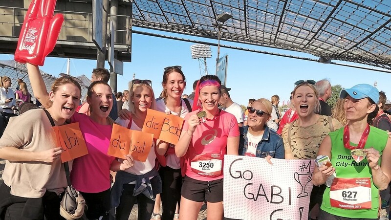 Gabriela Sußbauer (Mitte) präsentiert nach dem München-Marathon auf dem Gelände des Olympiaparks stolz ihre Teilnahme-Medaille - angefeuert von Fans und Freundinnen, die sie teilweise auch nach New York begleiten werden.