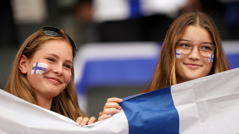 Zwei Finnland-Fans lächeln. Die skandinavischen Länder sind wieder auf den ersten Plätzen beim Weltglücksbericht.