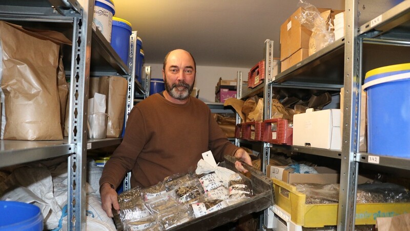 Fred Eickmeyer hält eine Kiste mit Lupinensaatgut in der Hand. Jedes Päckchen Saatgut unterscheidet sich und ist entsprechend beschriftet.