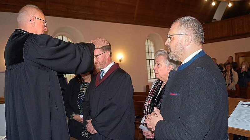 Durch Handauflegung überträgt Regionalbischof Klaus Stiegler im Beisein von Einsegnenden das Amt zum Prädikanten.