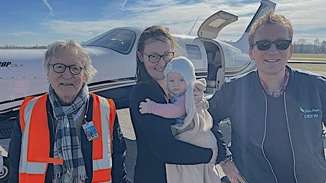 Die Piloten Dr. Michael Offermann (links) und Dr. Gerrit Arlt (rechts) mit der kleinen Marie und ihrer Mama.
