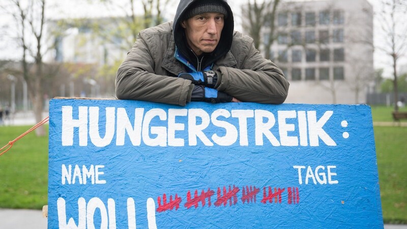 Aktivist Wolfgang Metzeler-Kick, der sich seit dem 7. März im Hungerstreik befindet, steht in einem Zeltlager im Spreebogenpark hinter einem Schild, auf dem die Anzahl seiner Tage im Hungerstreik markiert ist.