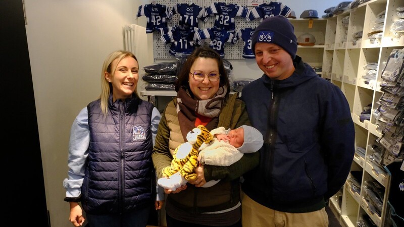 Franziska Heigl vom Tigers-Büro freut sich mit den Eltern Julia und Stefan Schlüßlbrunner, dass das Playoff-Baby Linus nun von einem Tigers-Teddy begleitet wird.