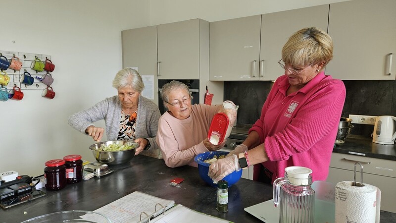 Einige Mitbewohner helfen gerne in der Küche. Mit Pflegerin Tanja Stein bereiten Roswitha und Karin den Teig für das Mittagessen vor.