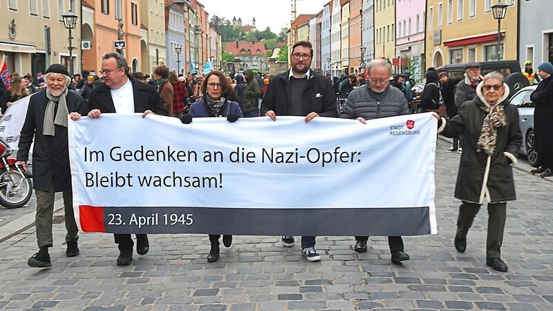 Oberbürgermeisterin Gertrud Maltz-Schwarzfischer (Mitte) führte den Gedenkweg an und trug mit den weiteren Rednern ein Transparent mit der klaren Mahnung: Bleibt wachsam.