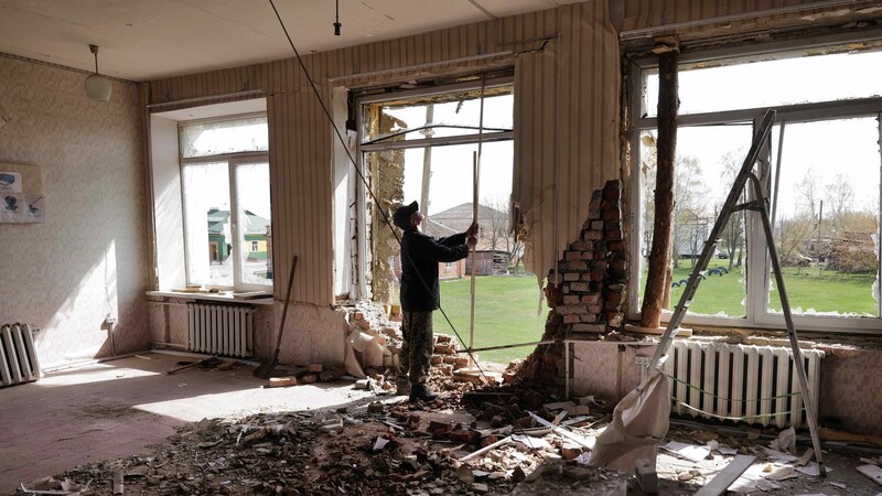 Nach dem Granateneinschlag im Schulgebäude räumt Sergej den Schutt zusammen. Der Handwerker hat hier als Kind selbst die Schulbank gedrückt.
