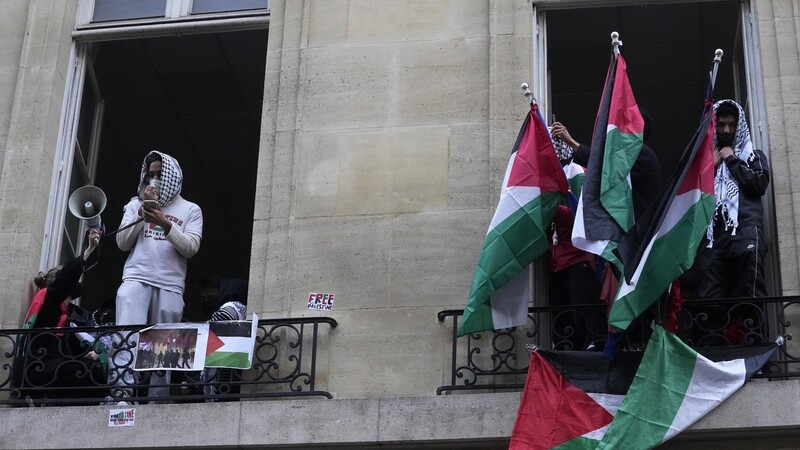 Studierende, die die Universität Sciences-Po blockieren, halten palästinensische Fahnen. Studenten in Paris, die sich von den Gaza-Solidaritätscamps an Universitäten in den Vereinigten Staaten inspirieren ließen, blockierten vergangene Woche den Zugang zu einem Campus-Gebäude einer angesehenen französischen Universität und veranlassten die Verwaltung, alle Vorlesungen online zu verlegen.