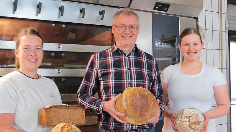 Die Bäckerinnen Andrea Neumeier (l.) und Angela Limbrunner (r.) schieben täglich frühmorgens Brote und Semmeln in den Ofen. Franz Josef Weber (Mitte), Vorsitzender der Bürgergenossenschaft, die die Bäckerei führt, ist stolz auf den Erfolg ihrer Arbeit.