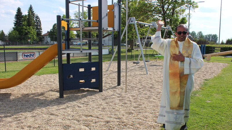 Pater Michael spendet dem neuen Spielplatz den kirchlichen Segen.