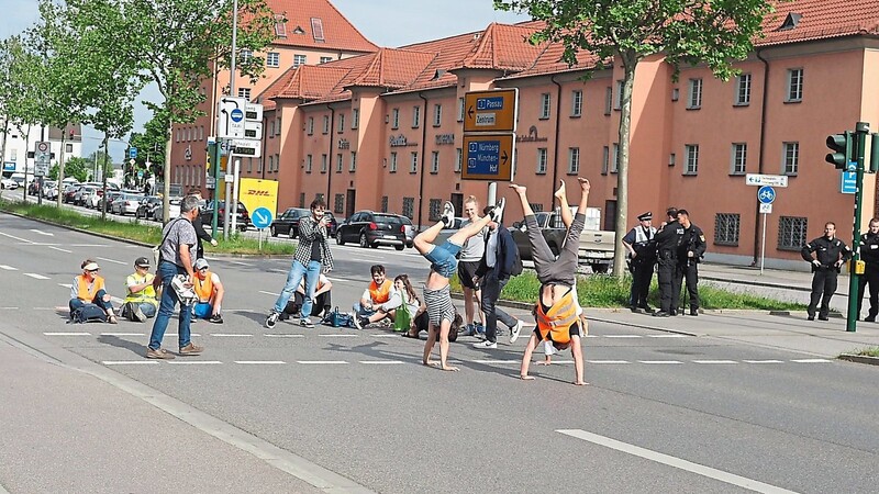 Die Aktivisten der Letzten Generation Regensburg vertrieben sich die Zeit auf der Straße vor den Arcaden am Mittwochabend unter anderem mit Handständen.
