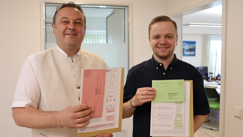Andreas Gritschmeier und Sebastian Zens (rechts) sind zuständig für die Wahl: Einen rosa Zettel gibt es für die Europawahl, einen grünen für den Bürgerentscheid ums Kinderhaus in Wörth.