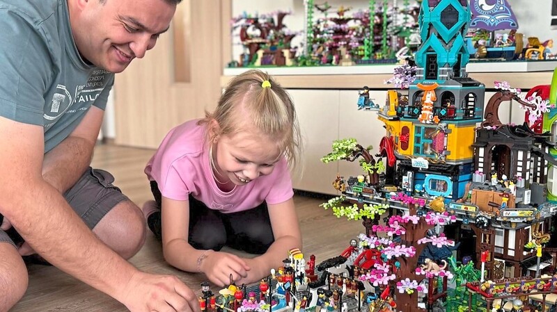 Matthias Vogl mit seiner achtjährigen Tochter Marie - und der Ninjago-Stadt. Die wird er auch bei der Lego-Messe am Wochenende in der Neustädter Stadthalle zeigen.