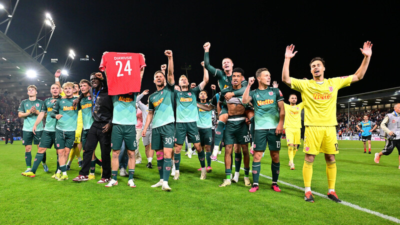 Zurück in der 2. Bundesliga: Die Jahn-Spieler feiern in Wiesbaden vor der Fankurve. Nicht fehlen darf dabei das Trikot mit der Nummer 24 des während der Saison verstorbenen Agyemang Diawusie.